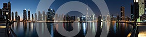 Business bay skyline with reflection in the water at night, Dubai, UAE