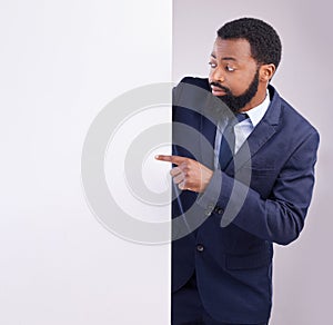 Business, black man and pointing to board in white background, studio or mockup information space. Corporate worker