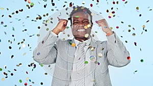 Business black man, success and celebration in confetti for winning, promotion or vote against a studio background