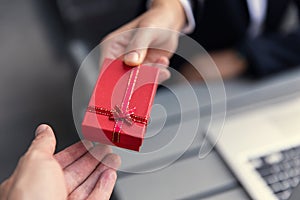 Business boss giving present gift box to office staff partner for job bonus concept photo