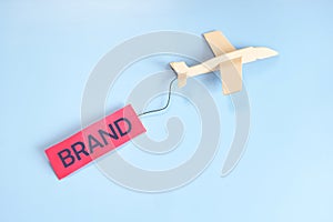 Business branding campaign success and launching concept. Airplane flying with brand tag in blue background with copy space.