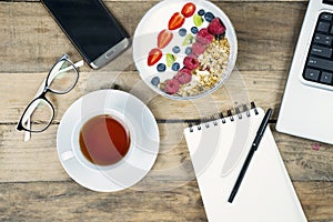 Business breakfast with tea and yogurt on desk