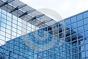 Business building with modern glass exterior on blue sky background.