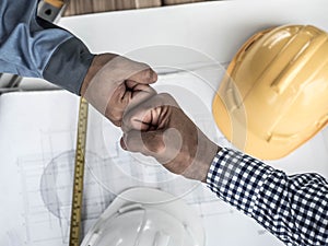 Business, building, teamwork, gesture and people concept - group of smiling builders in hardhats greeting each other with Hand