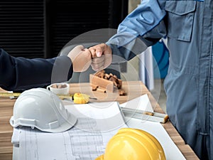 Business, building, teamwork, gesture and people concept - group of smiling builders in hardhats greeting each other with Hand