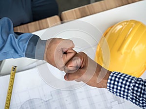 Business, building, teamwork, gesture and people concept - group of smiling builders in hardhats greeting each other with Hand