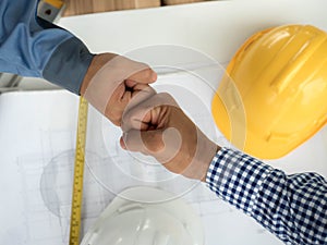 Business, building, teamwork, gesture and people concept - group of smiling builders in hardhats greeting each other with Hand