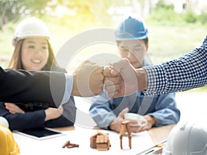 Business, building, teamwork, gesture and people concept - group of smiling builders in hardhats greeting each other with Hand