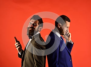 Business call. Machos in classic suits talk on cell phone. photo