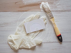 Business card on the background of repair work, with a paint brush and gloves.