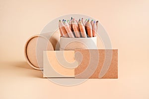 Business card mockup and a set of colored pencils, eco kraft paper on a beige background