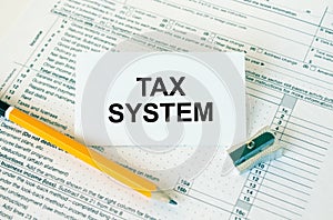 Business card with text Tax System on financial docs