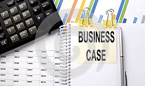 BUSINESS CASE text, written on a sticker with calculator,pen on the chart background