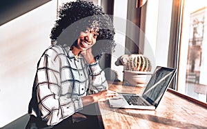 Business casual lifestyle.Beautiful african american woman working in a beautiful cozy office near the window looking at camera