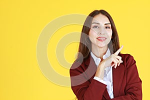 Business Caucasian woman in red suit smiling and thinking for good idea on yellow background