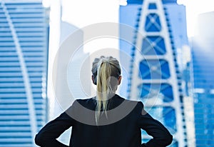 Business challenge. Confident businesswoman overlooking the city center high-rises