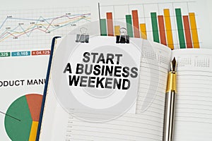 On the business charts is a notepad with the inscription - Start a Business Weekend