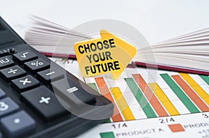 On the business charts there is a notepad, a pen and an arrow sticker with the inscription - Choose Your Future