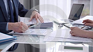 Business colleagues accountants or auditors reviewing financial data in office. Two professionals analyzing paper