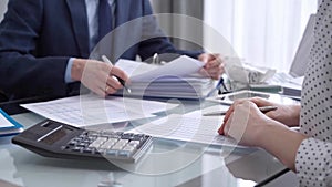 Business colleagues accountants or auditors reviewing financial data in office. Two professionals analyzing paper