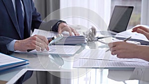 Business colleagues accountants or auditors reviewing financial data in office. Two professionals analyzing paper