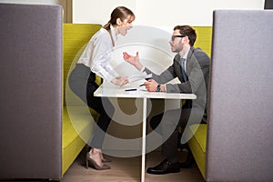 Business colleagues arguing while sitting at table with papers