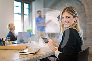 Business colleagues in conference meeting room during presentation. Businesswoman using digital tablet