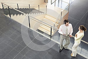 Business Colleagues Conversing By Railing In Office
