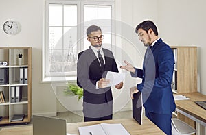 Business colleagues discuss and review paper documents while working in office or law agency.