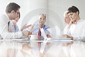 Business colleagues discussing during meeting in boardroom at modern office
