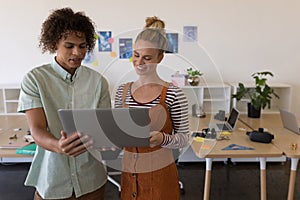 Business colleagues discussing over laptop in office