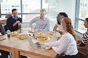 Business colleagues discussing while sitting around breakfast table