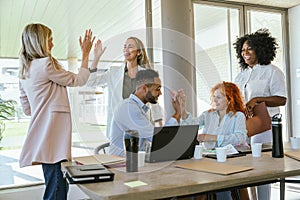 Business colleagues high-fiving while celebrating success