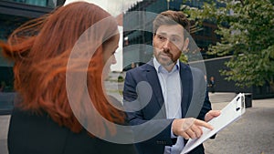 Business colleagues man and woman arguing disagreeing bad business contract in city partners having conflict dispute photo