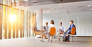 Business colleagues planning strategy while sitting on chairs during meeting photo