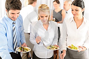 Business colleagues serve themselves at buffet