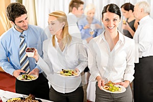 Business colleagues serve themselves at buffet