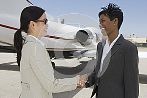 Business Colleagues Shaking Hands At Airfield photo
