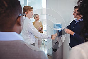 Business colleagues shaking hands at office