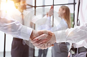 Business colleagues shaking hands in an office hallway