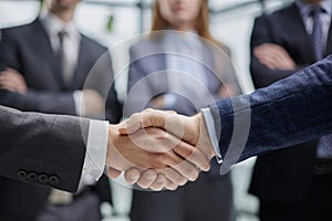 Business colleagues shaking hands in an office hallway