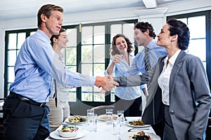 Business colleagues shaking hands after a successful lunch meeting