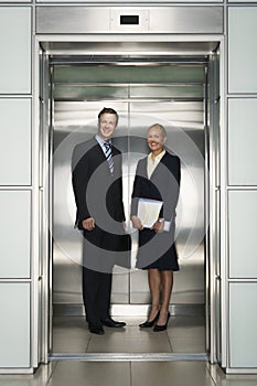 Business Colleagues Standing In Elevator