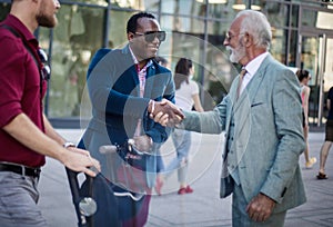 Business colleagues standing outdoors and discussing. Small Group of business men talking on the street