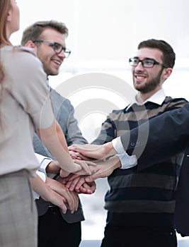 Business colleagues with their hands stacked together