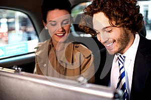 Business colleagues travelling together in taxi cab