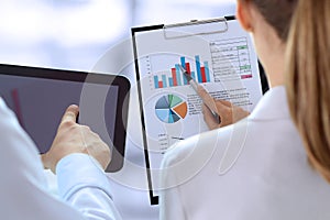 Business colleagues working and analyzing financial figures on a graphs