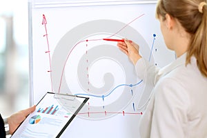 Business colleagues working and analyzing financial figures on a graphs