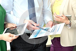 Business colleagues working and analyzing financial figures on a graphs