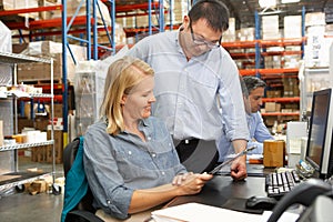 Business Colleagues Working At Desk In Warehouse